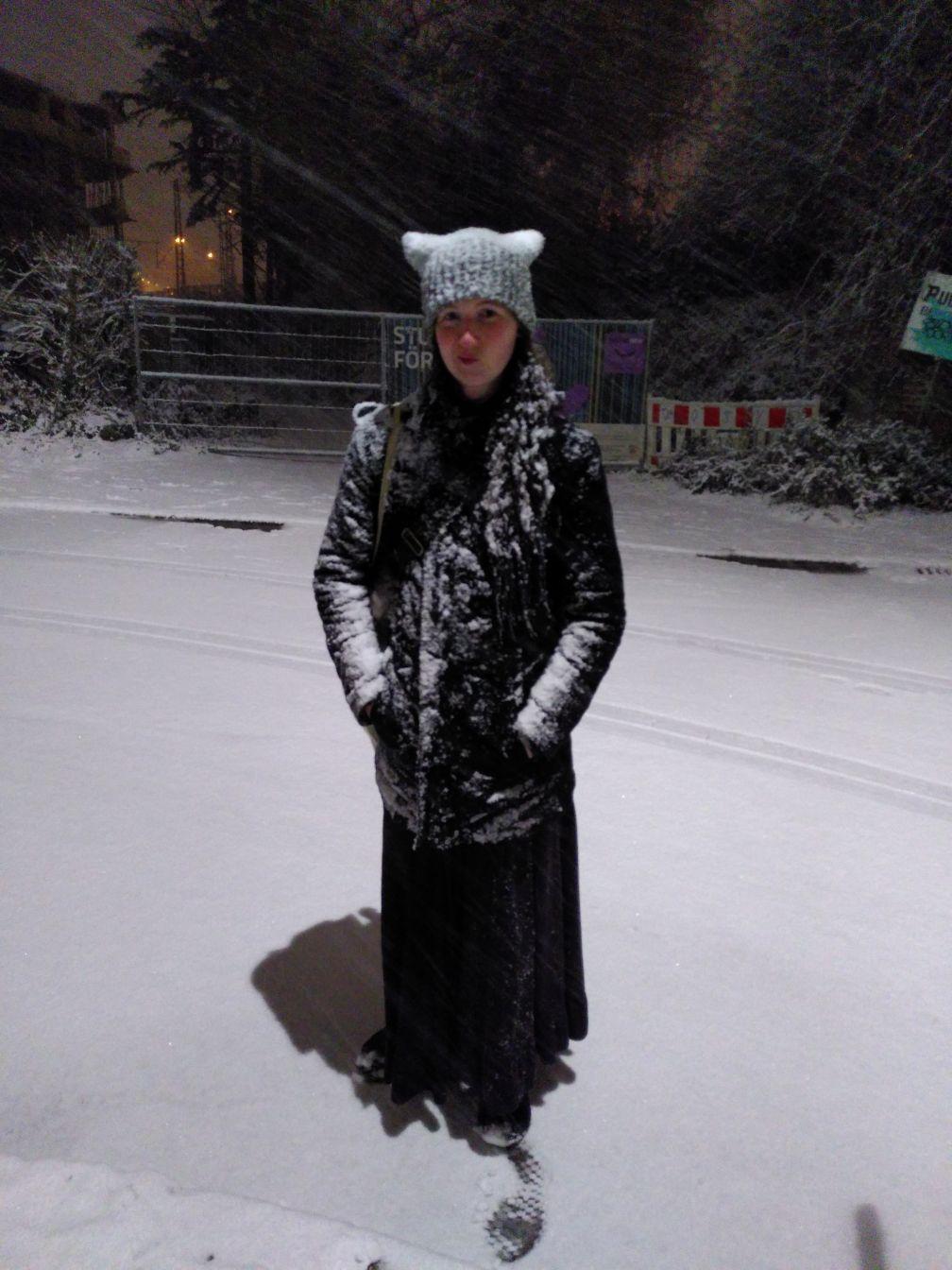 wide/distant photo of mew standing on a street, looking at the camera.
The street (and pedestrian paths on the side) are almost completely covered by a layer of snow.
My jacket and knitted hat (with ears) have quite some snow on them, too.
The black long skirt somehow seems to be unaffected.
The face is making a slight semj-amused grimmace, pulling lips to one side.
You can see hints of snowflakes falling, as they leave faint lines in the picture. wide/distant photo of mew standing on a street, looking at the camera.
The street (and pedestrian paths on the side) are almost completely covered by a layer of snow.
My jacket and knitted hat (with ears) have quite some snow on them, too.
The black long skirt somehow seems to be unaffected.
The face is making a slight semj-amused grimmace, pulling lips to one side.
You can see hints of snowflakes falling, as they leave faint lines in the picture.